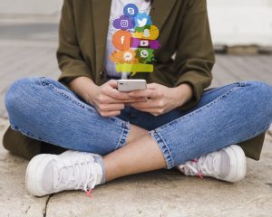 Lady sitting crossed leg on her phone scrolling through Social Media