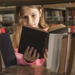 Fostering in Nottingham - Girl reading a book in a library