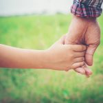 Fostering in Nottingham - parent and child holding hands in park