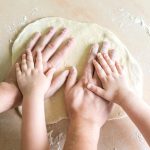 Top view of parent and child baking together, needing dough. Foster care Nottingham